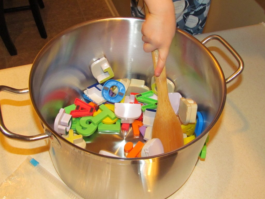 While making dinner, let your preschooler make some "alphabet soup" at the counter. Here's how we play this super simple letter sounds game...
