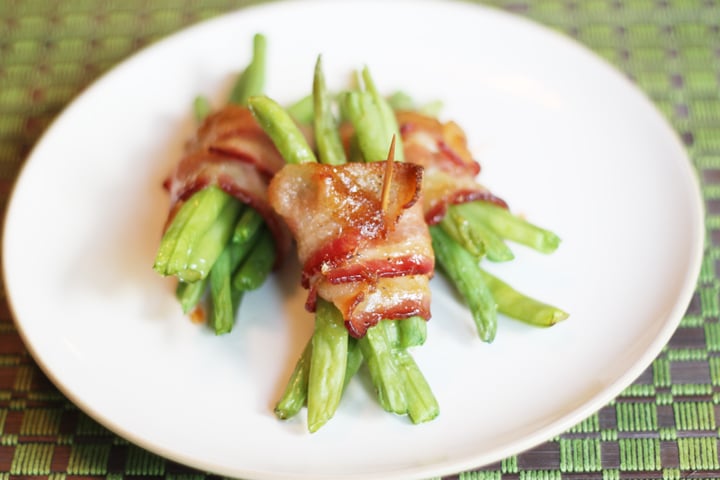 Bacon wrapped green beans on a white plate