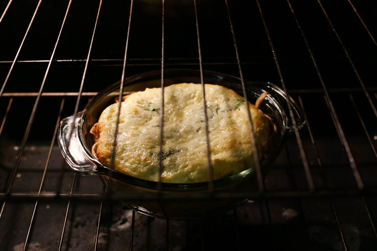 spinach and bacon quiche baking in an oven