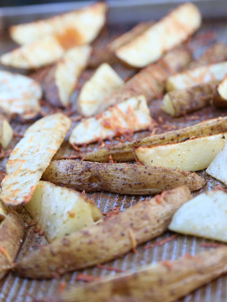 Cooked parmesan potato wedges on a baking sheet