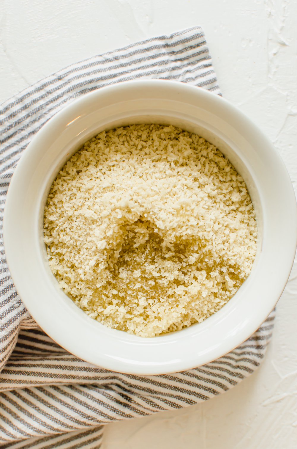 Bowl of panko breadcrumbs with olive oil mixed into them.