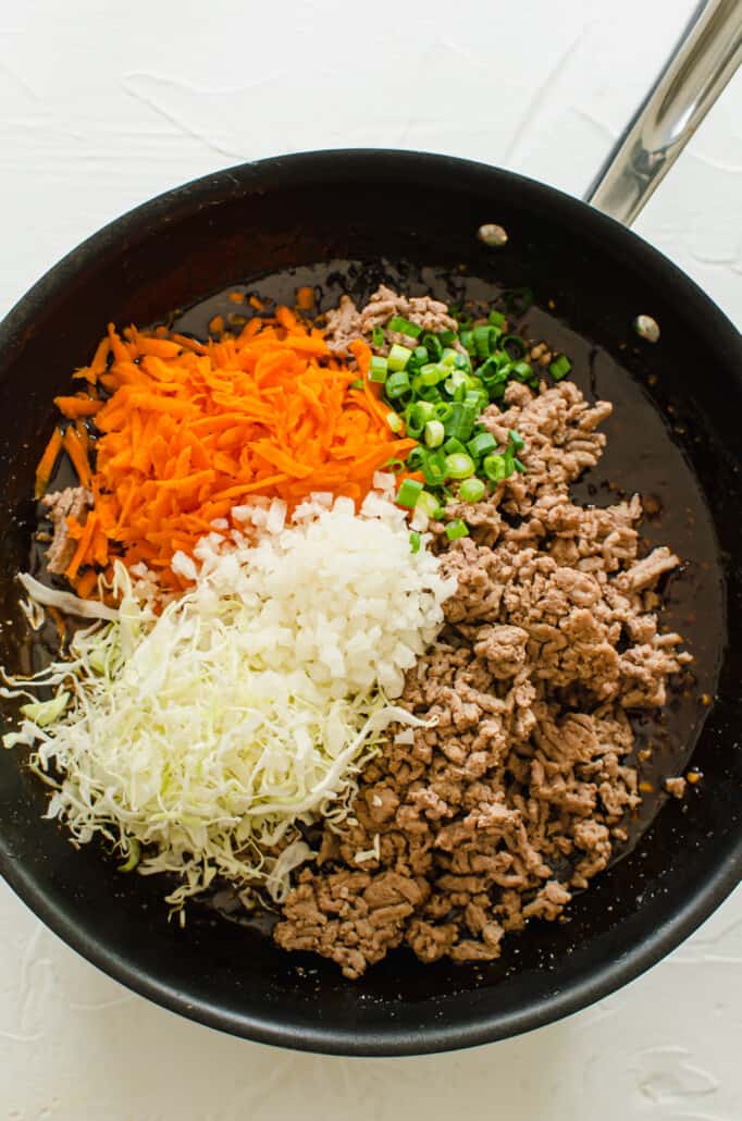individual ingredients for lettuce wraps in a skillet