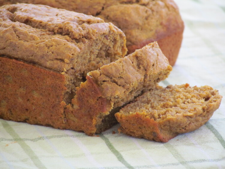 Two loaves of pumpkin banana bread with a couple slices cut from one of the loaves.