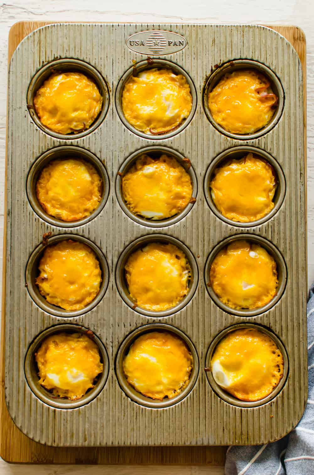 Ham and cheese egg cups straight from the oven in the muffin tin.