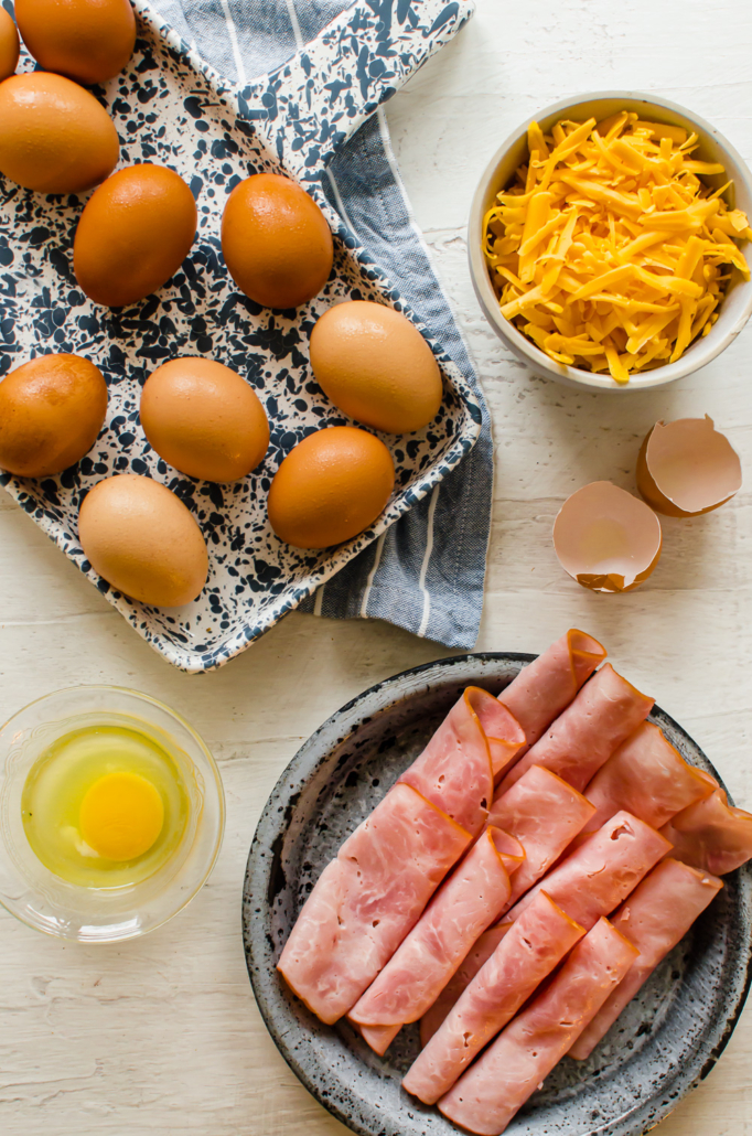 ingredients for baked egg cups, including eggs, ham, and cheese