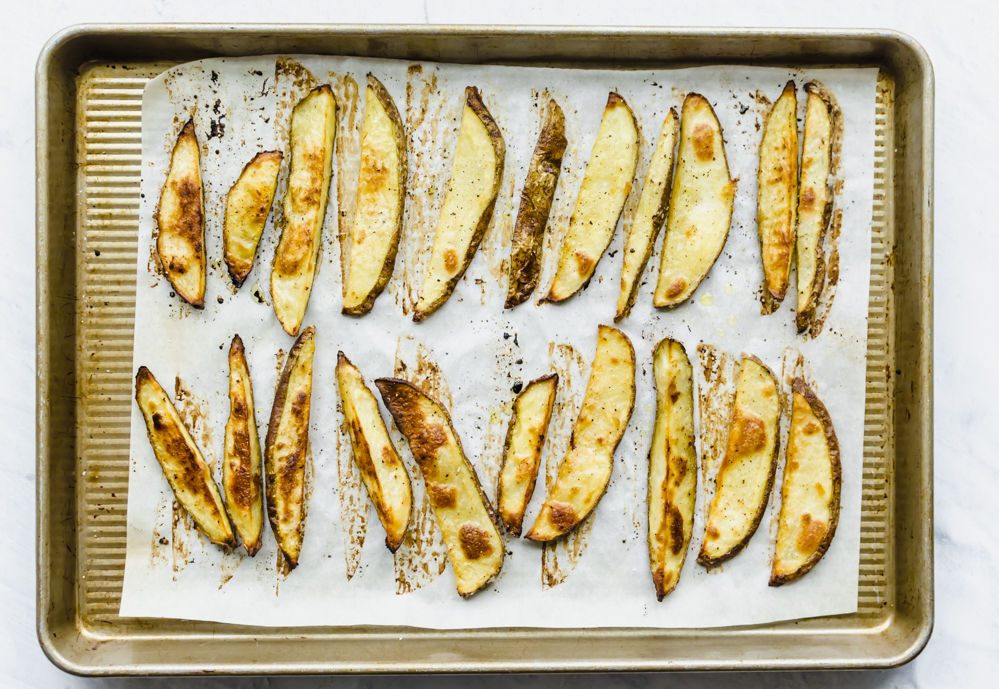 oven baked steak fries on a sheet pan