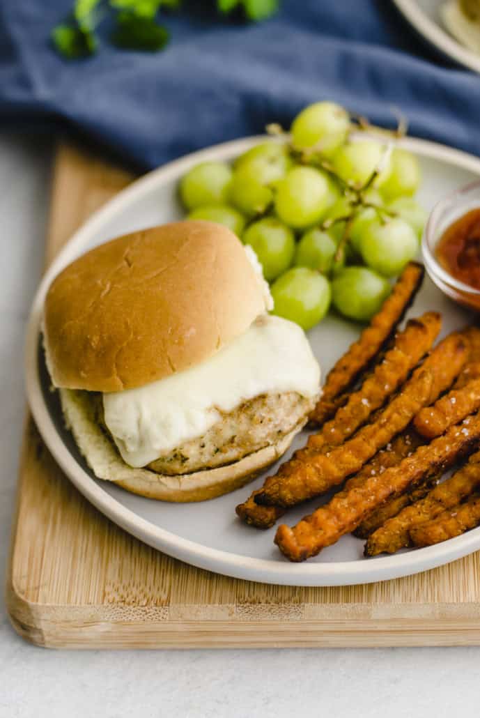 chicken burger on a bun with cheese on a plate