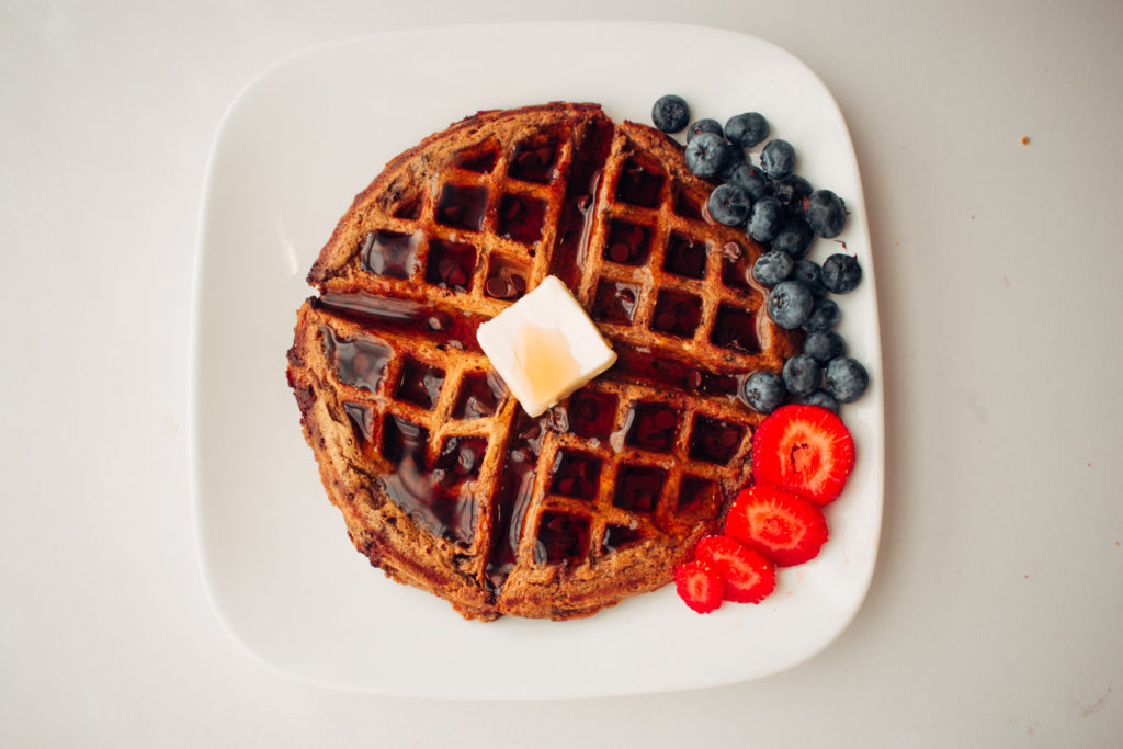 Pumpkin waffle on a plate with strawberries and blueberries