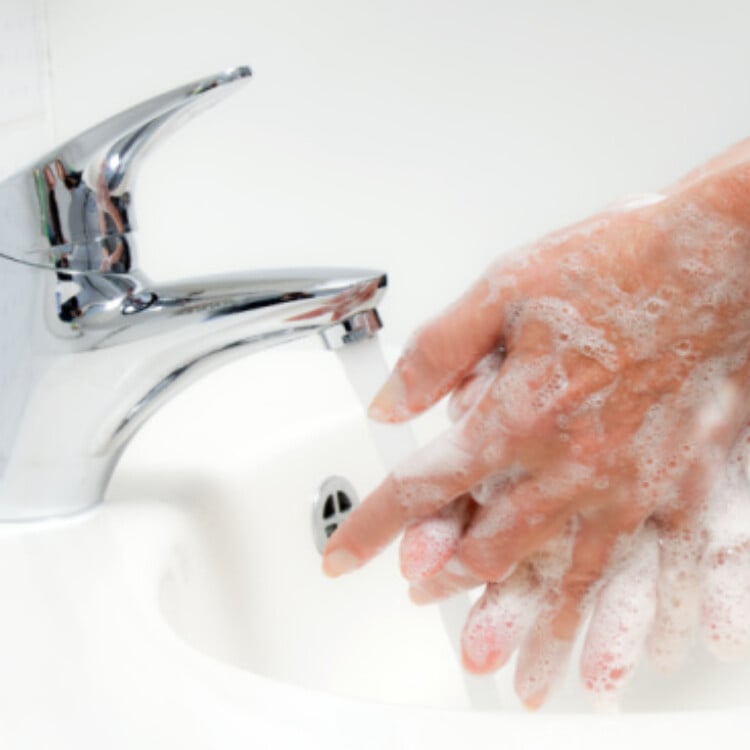 Washing hands with soap under running water.