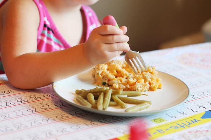 A child eating mac and cheese with a fork.