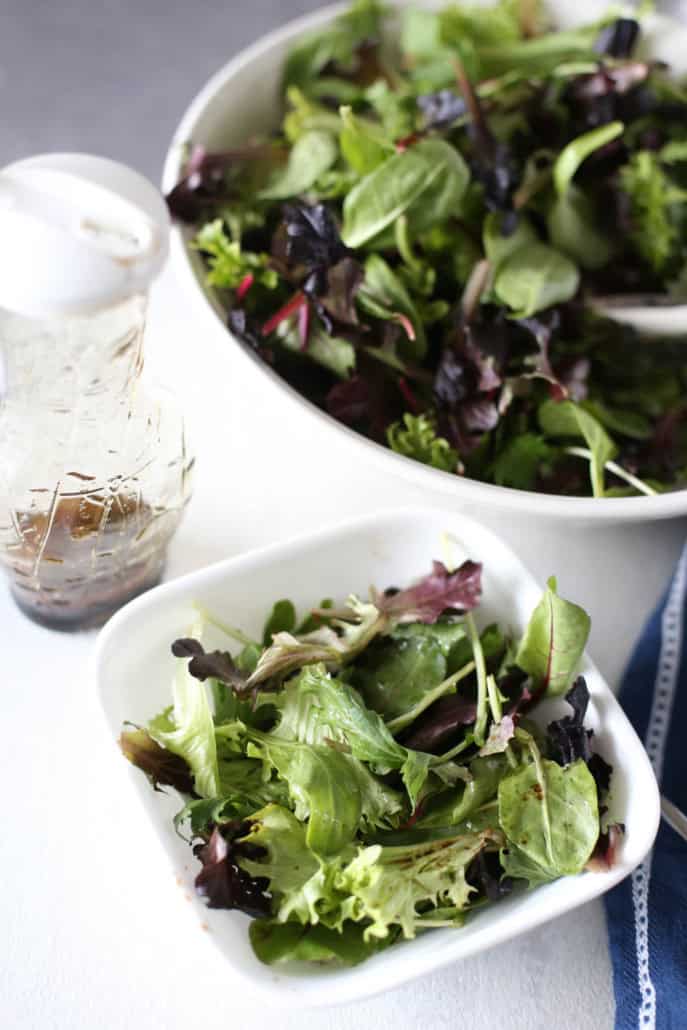 Wilted Lettuce Salad in a bowl with dressing nearby