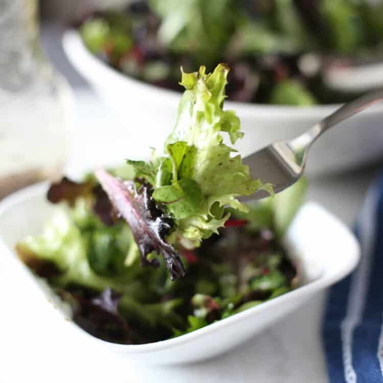 Wilted Lettuce Salad in a bowl with a bite being lifted by a fork.