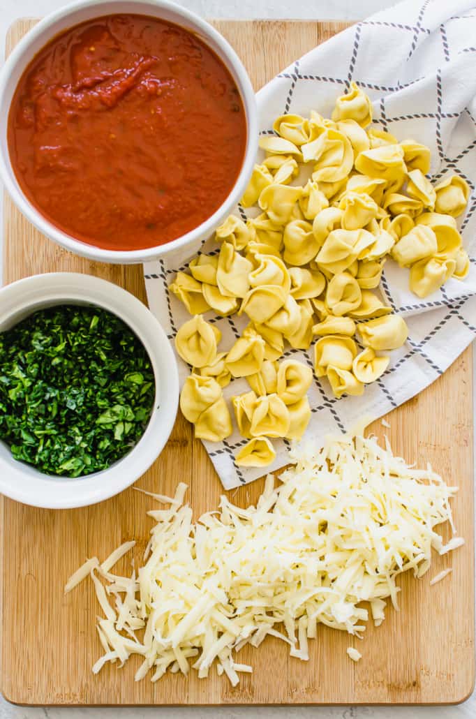 Ingredients for Baked Tortellini on a cutting board 