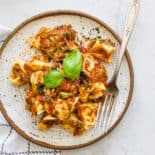 A serving of cheese tortellini baked with marinara sauce on a plate.