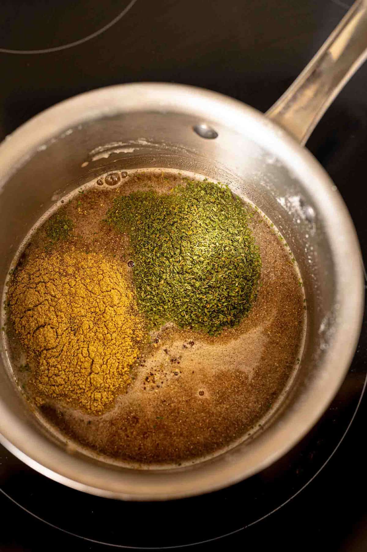 overhead process shot of butter and seasonings in a pot