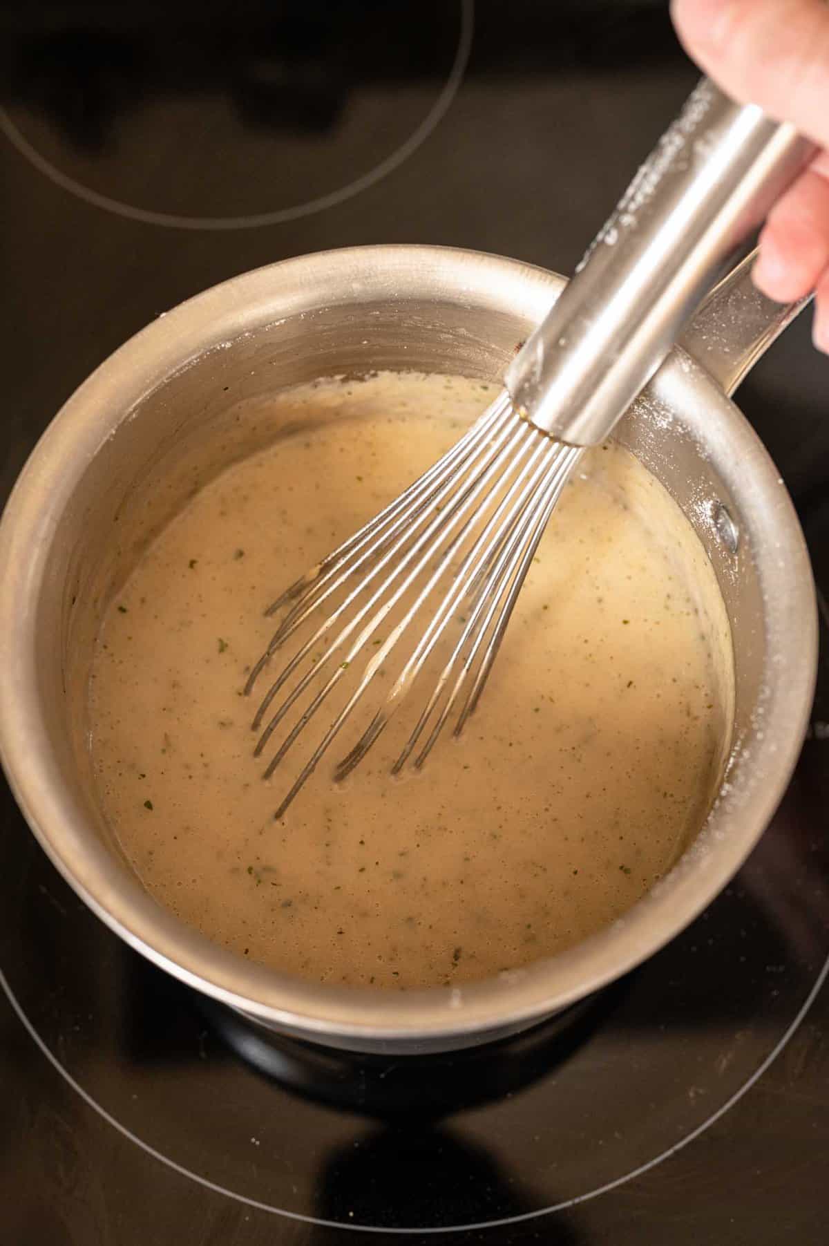 whisking cream of chicken soup in a pot