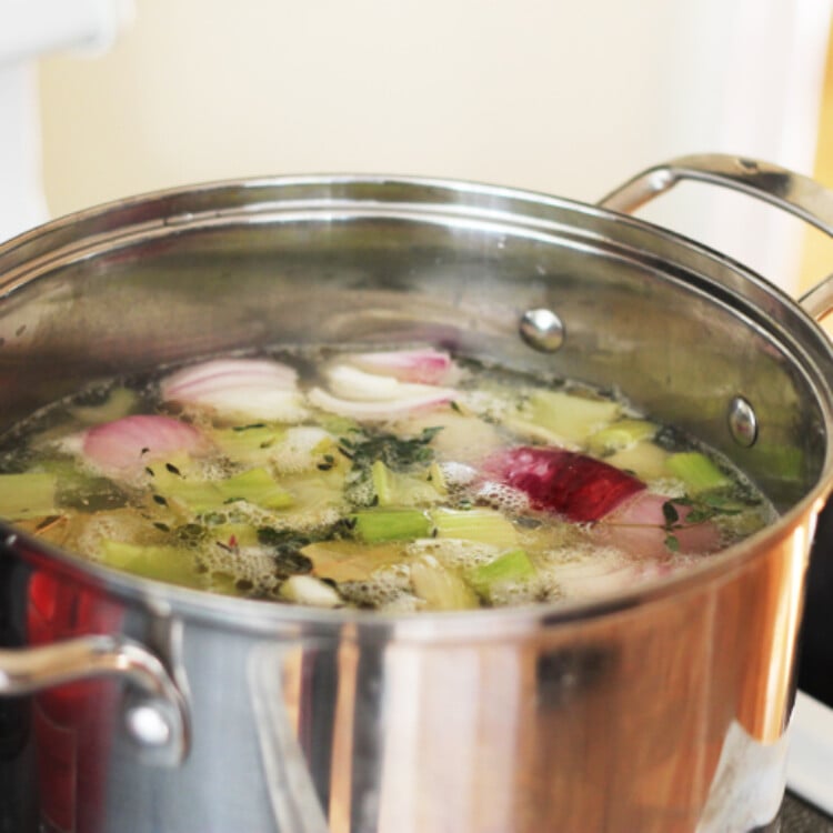 Large stock pot with onions, celery, seasonings, and chicken bones, etc. to make homemade chicken broth.