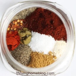 Piles of spices in a jar that make up taco seasoning ready to be mixed together.