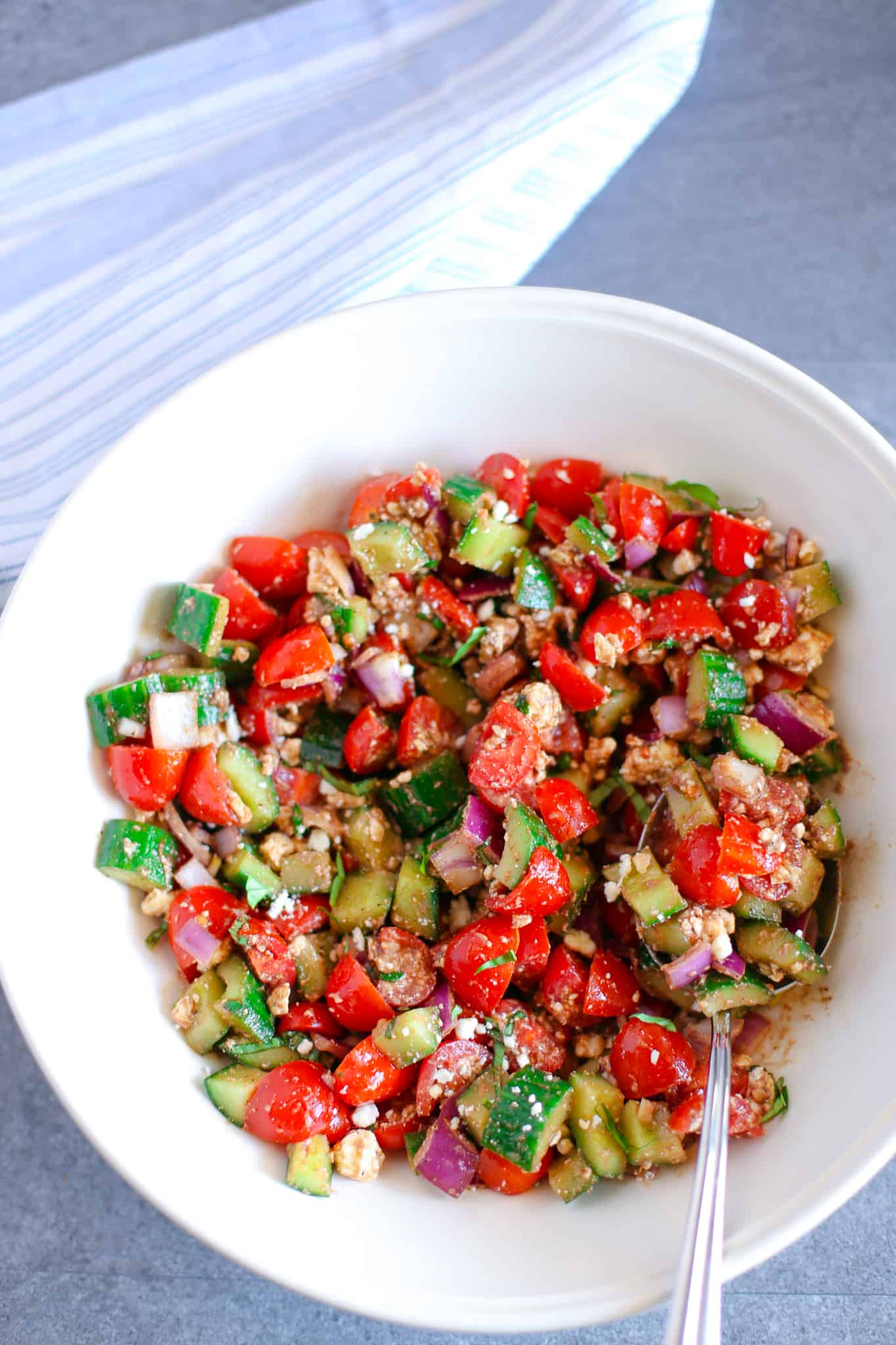 Cucumber Tomato Feta Salad in a white bowl ready to serve.