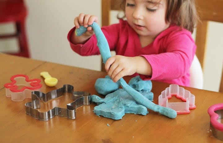 A child playing with playdough.