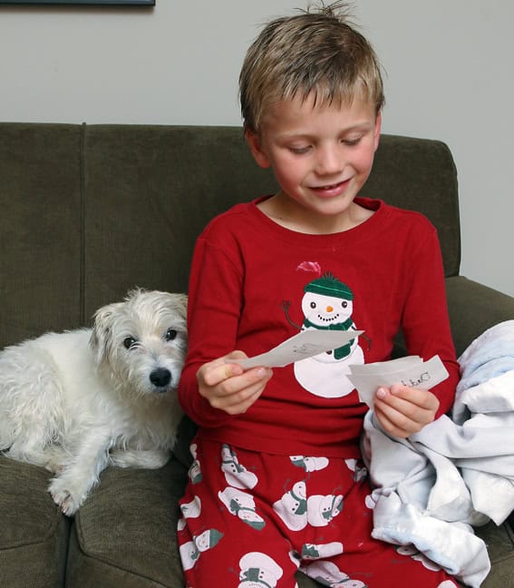 Small child looking a pieces of paper while playing DIY Apples to Apples.