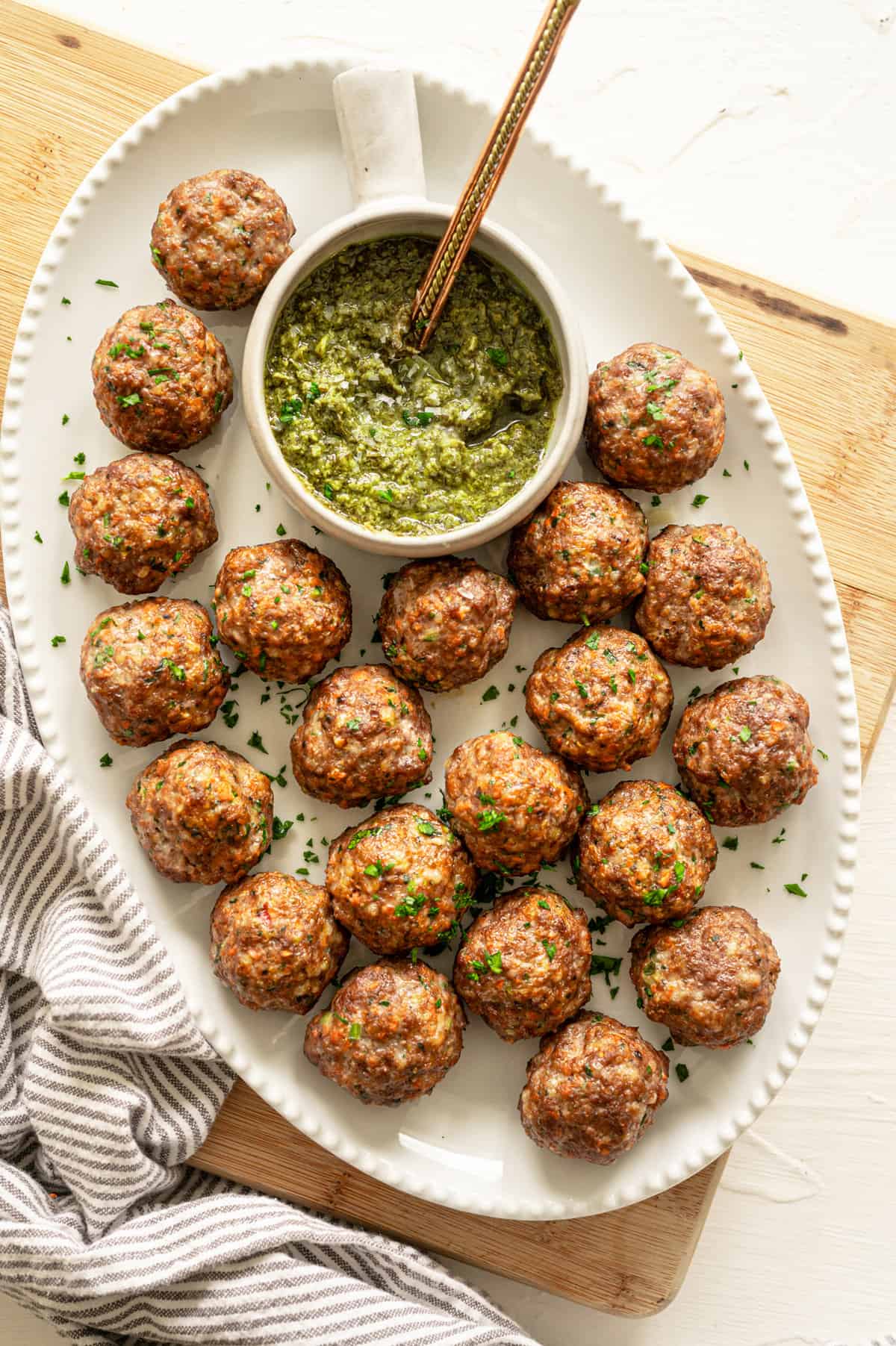 air fryer meatballs on a platter with pesto in a small bowl