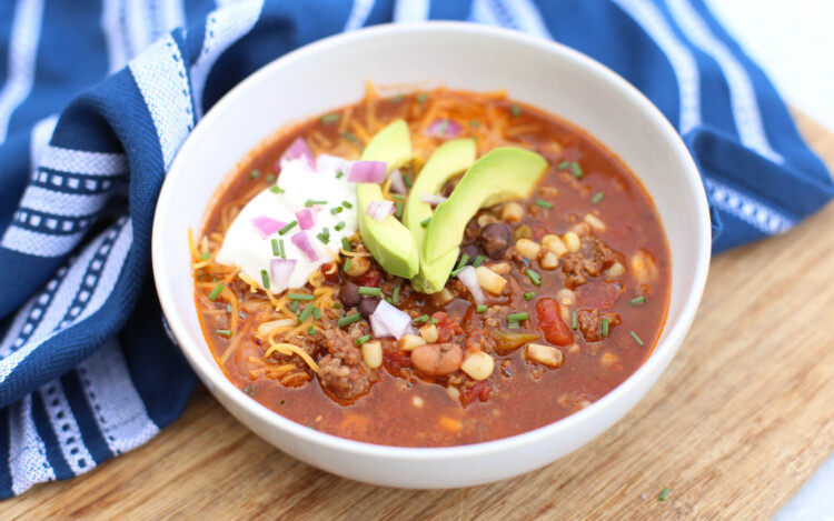 Mexican soup in a white bowl with toppings