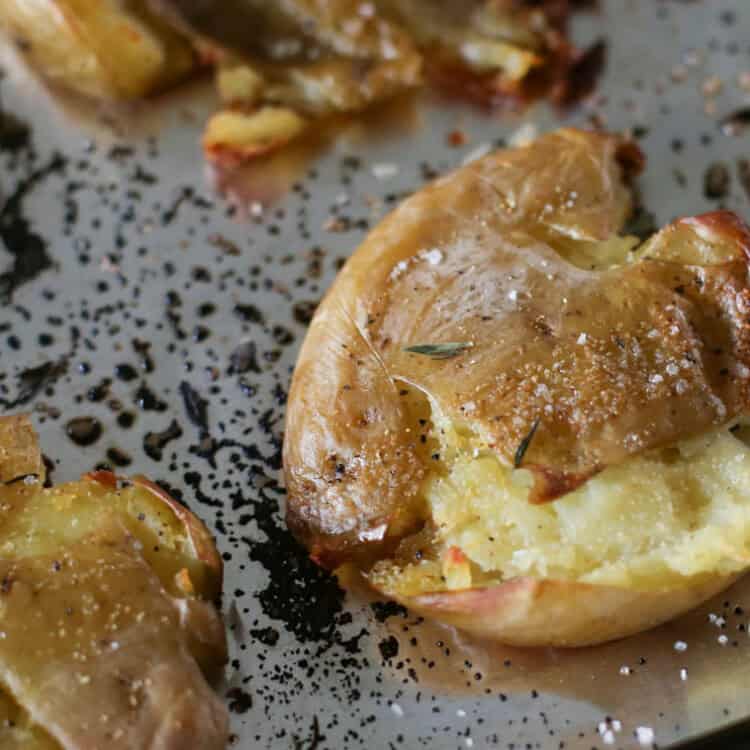 A crispy smashed potato on a baking sheet.