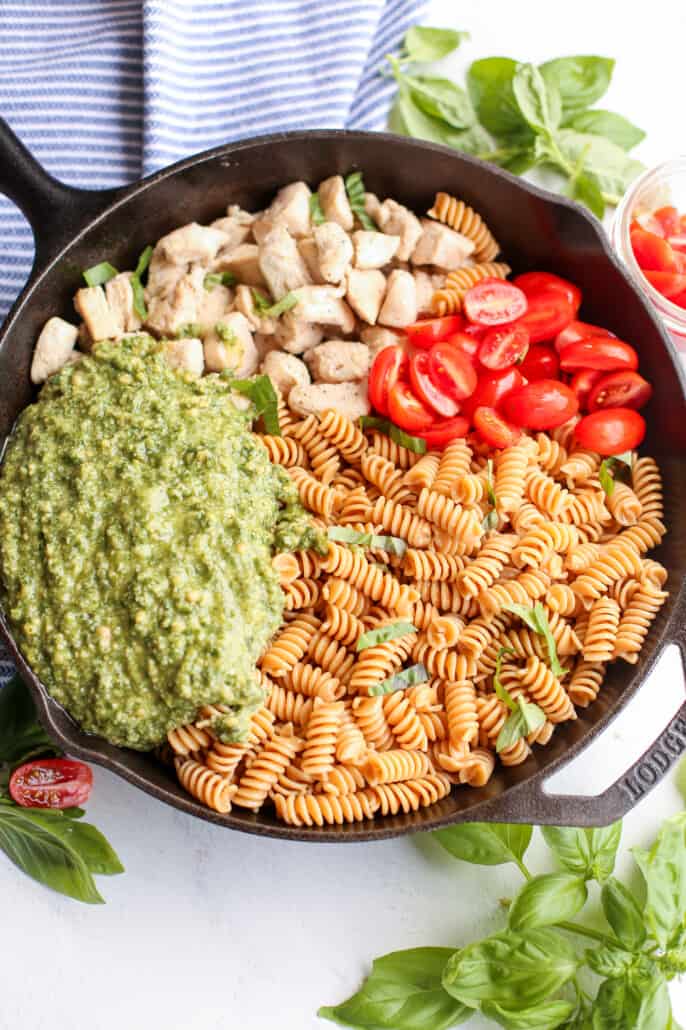overhead shot of components of chicken pesto pasta in a skillet