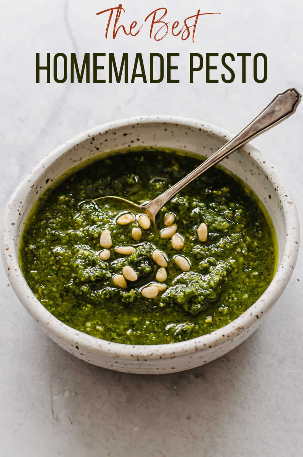 Homemade pesto in a bowl with pine nuts sprinkled on top.