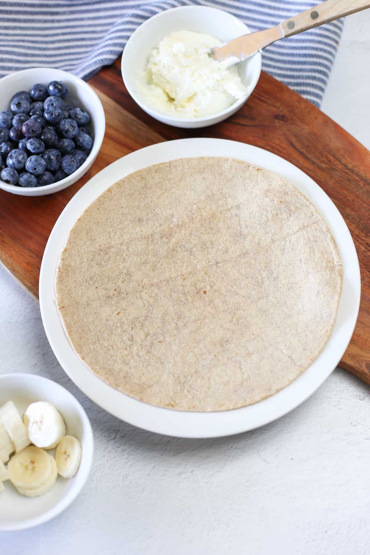 A whole wheat tortilla on a plate with nothing on it. 