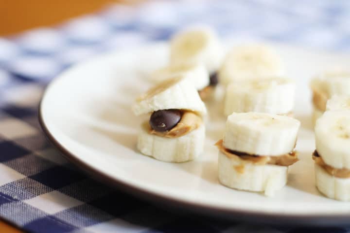 Banana sliced in half with peanut butter and dark chocolate in the middle. 