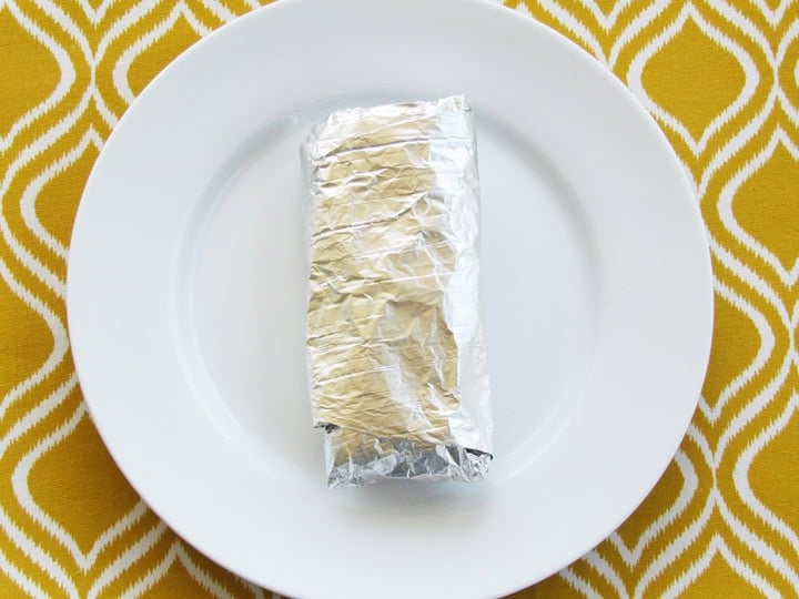 A lunch wrap wrapped in foil ready to be frozen.