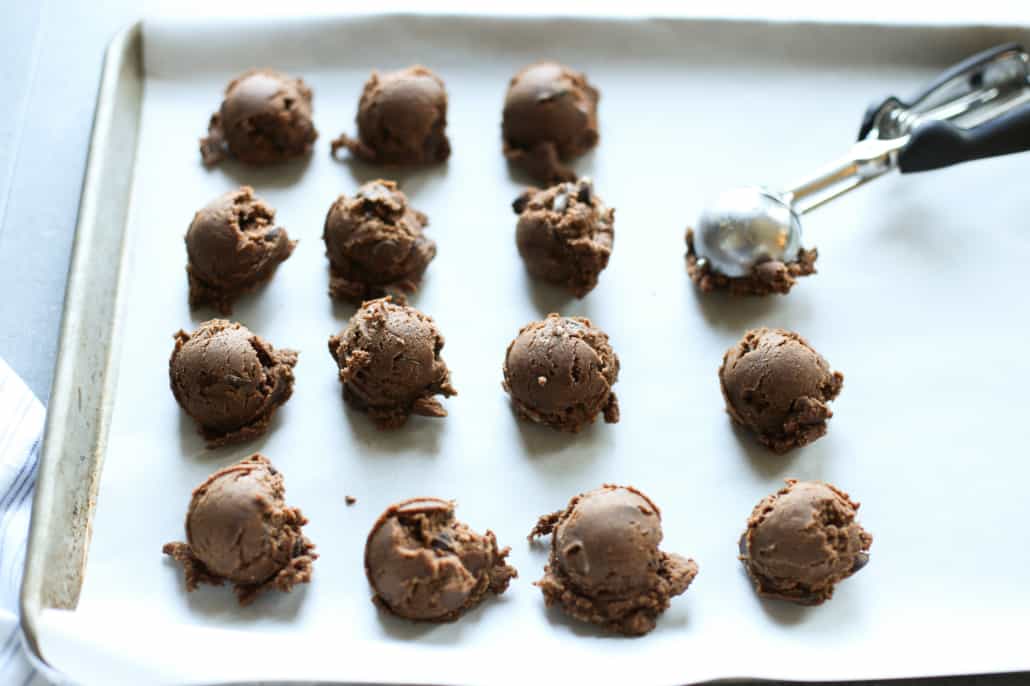 Cookie dough being scooped onto a baking sheet 