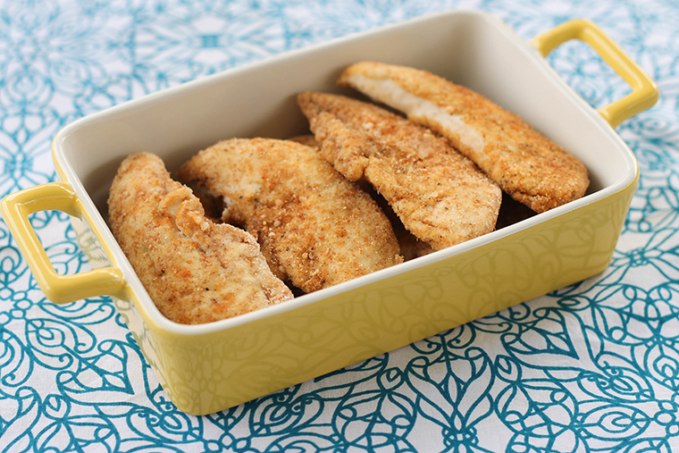 Oven baked chicken tenders in a baking dish.