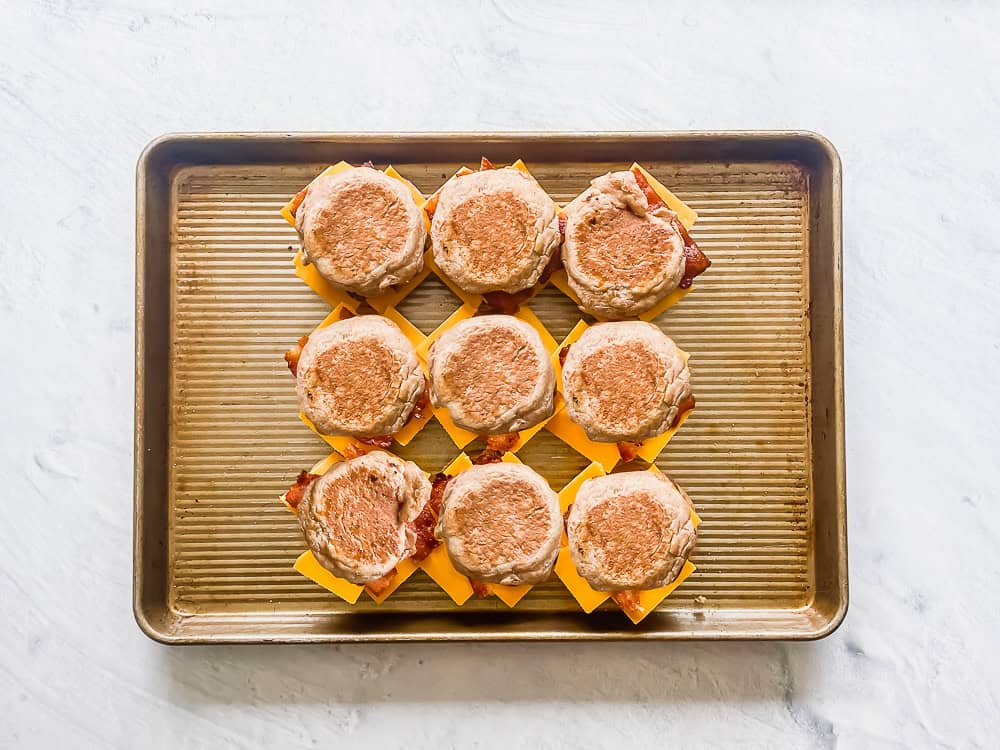 breakfast sandwiches lined up on a sheet pan.