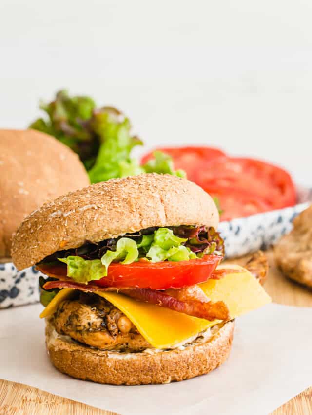 The ultimate Grilled Chicken Sandwich on parchment paper on a cutting board.