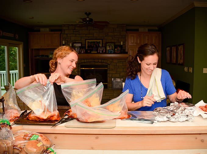 Two woman prepping freezer meals.