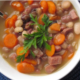 Ham and bean soup on a bowl with fresh parsley in a white bowl.