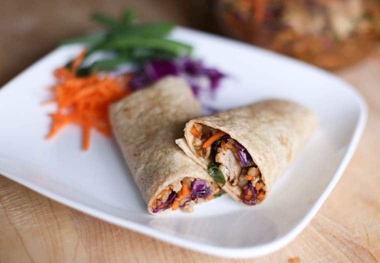 Asian chicken wraps cut in half on a white plate. 