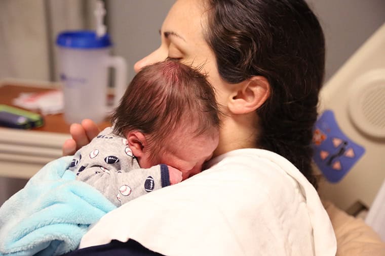 Newborn baby on a moms shoulder