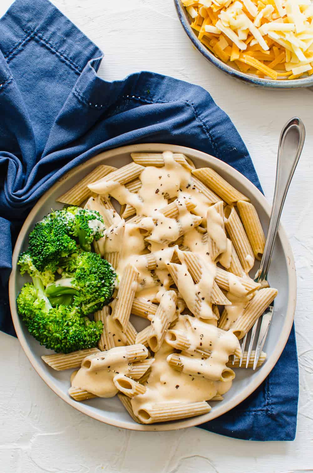 shot of cheese sauce for pasta with steamed broccoli on the side