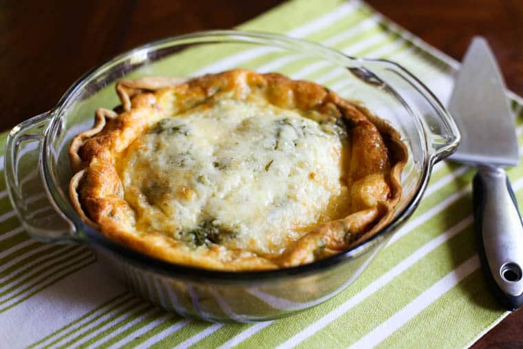 baked quiche on a table with a pie server nearby