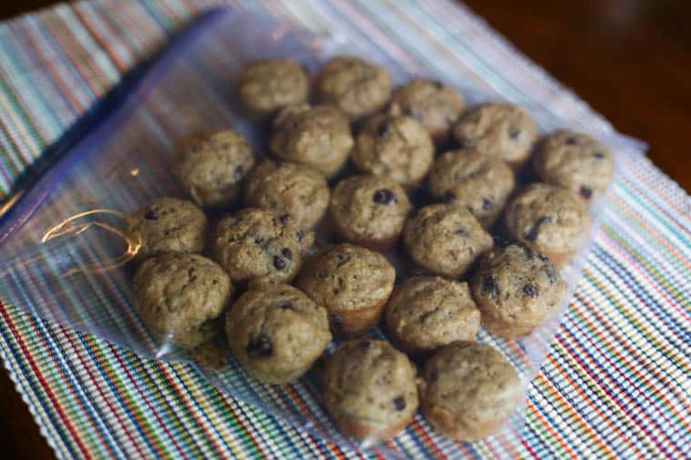 Mini muffins in a single layer inside a freezer storage bag.