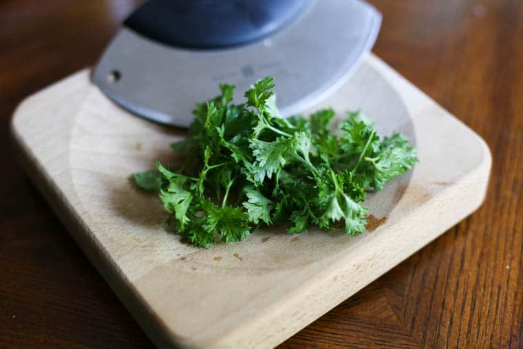 Parsley being diced up for garlic herb butter. 