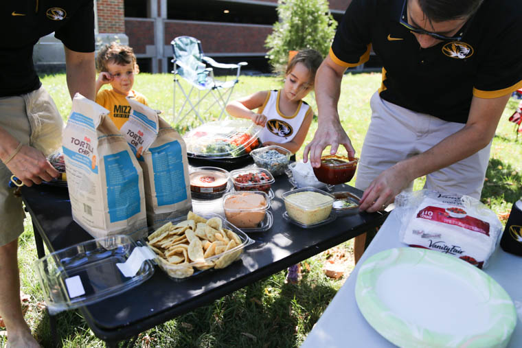 tailgate with food on table and people eating