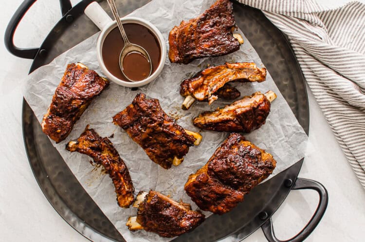 Baby back ribs on a serving tray lined with parchment paper.