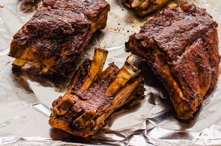 crock pot baby back ribs that have been broiled on a sheet pan with BBQ sauce