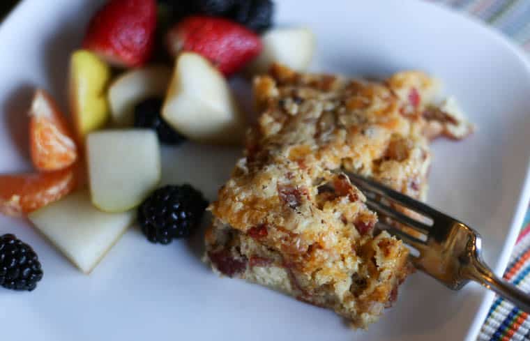 Egg casserole with bacon being cut into