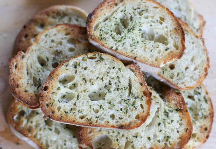 Texas toast stacked up ready to serve with parsley sprinkled on it.